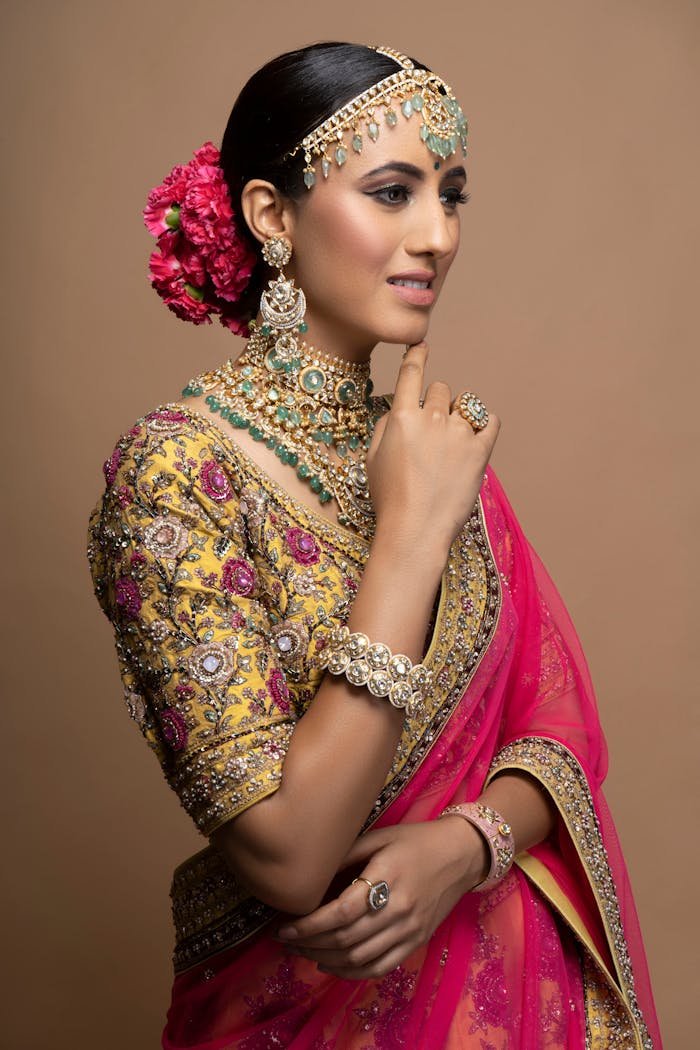 Portrait of a woman in traditional Indian attire with intricate jewelry and floral accessories, exuding elegance.